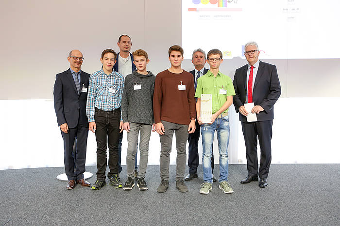 Auf dem Foto (vlnr): Schulleiter Dr. Heinz Sommerer, Projektlehrkraft BerR Jürgen Meier, vbw-Hauptgeschäftsführer und Laudator Bertram Brossardt, Moderator Michael Mötter sowie vier Schüler der Projektgruppe